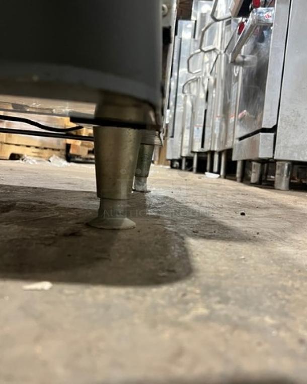 Cornelius ED200 beverage dispenser legs, showing stainless steel construction and support structure, on warehouse floor.