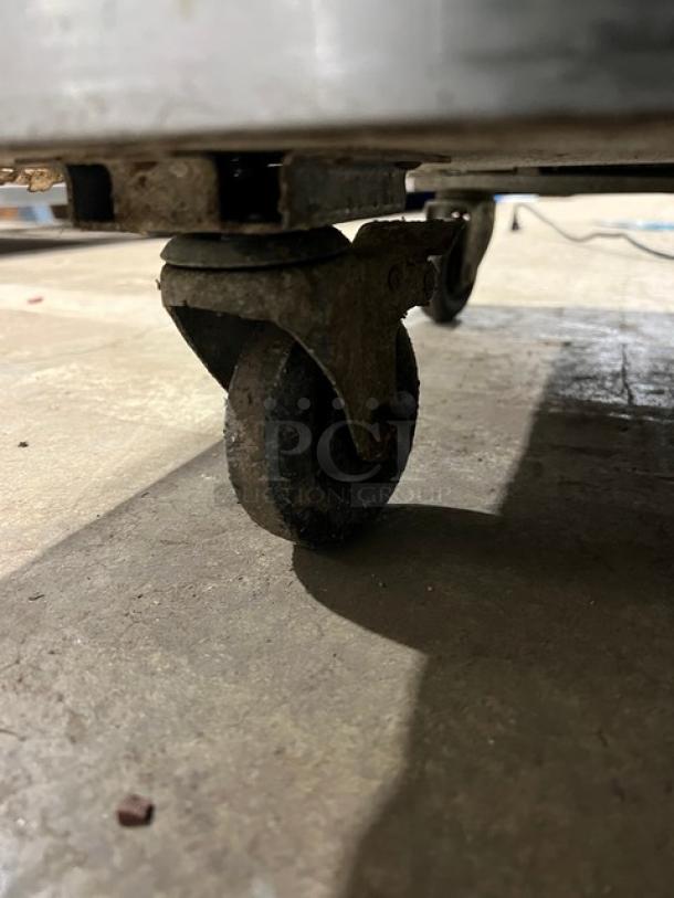 Close-up of a caster wheel on an Atosa MGF8408GR commercial refrigerator.