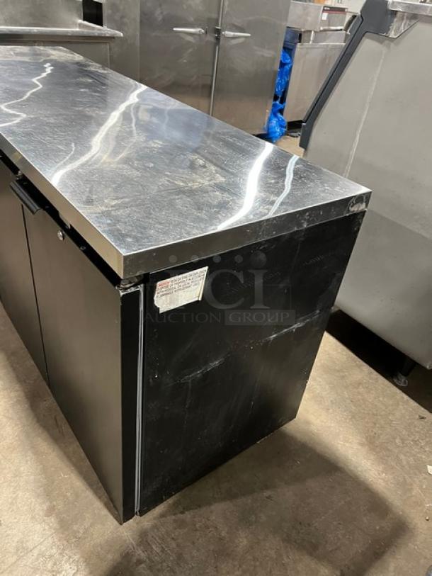 Continental BB79N 79" black 3-door back bar refrigerator with stainless steel worktop and poly-coated wired rack. Model SN: 15994550.