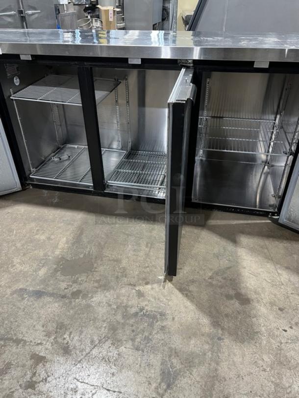 Continental BB79N black 3-door back bar refrigerator with stainless steel worktop and poly-coated wired rack, excellent condition.