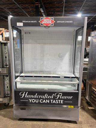 Ojeda ALPA120G2 refrigerated merchandiser display case with pull-down night curtain, Dietz & Watson branding, 120V, on legs.