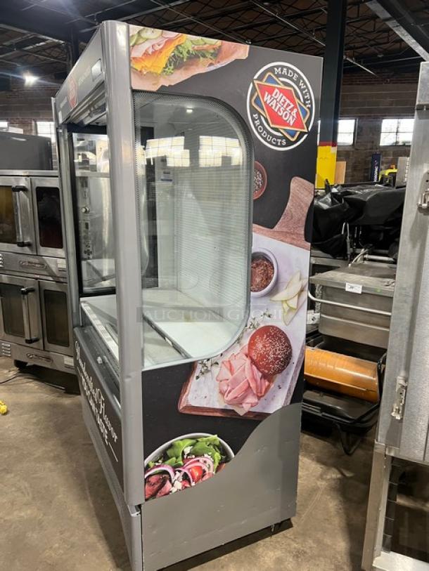 Ojeda ALPA120G2 refrigerated merchandiser display case with pull-down night curtain, featuring Dietz & Watson branding.