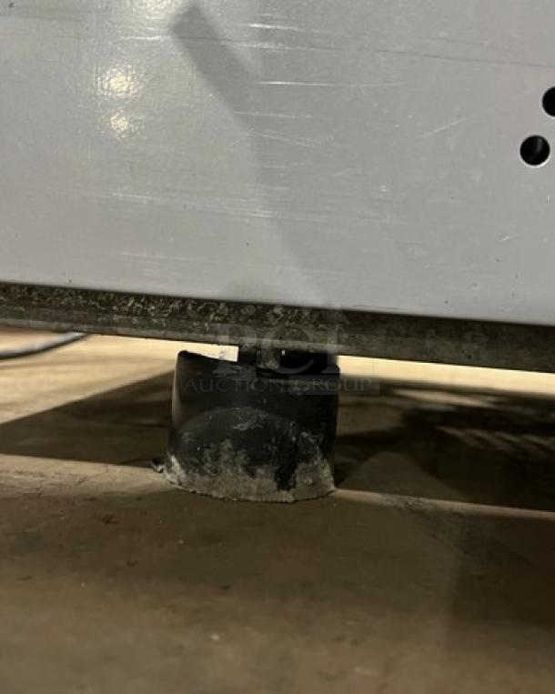 Ojeda ALPA120G2 refrigerated display case leg, showing wear, part of commercial open grab-n-go merchandiser with night curtain.