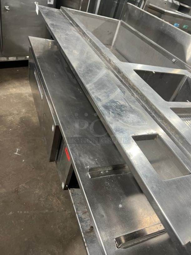 Custom commercial stainless steel bar/cocktail station with single drawer, backsplash, ice bin, sink, and drain board.