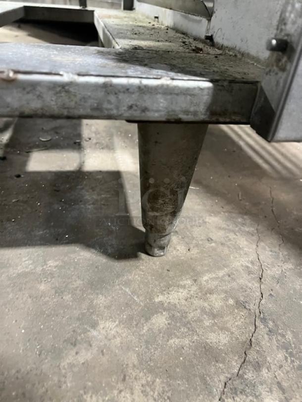 Custom stainless steel bar station, single drawer, ice bin, sink, drain board, on legs, visible wear, ideal for commercial use.