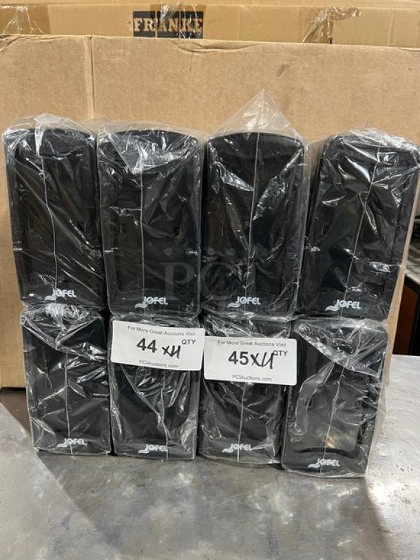 NEW Jofel black countertop/tabletop tall-fold napkin dispensers, sealed in plastic, commercial-grade, auction labels indicating 44 and 45 units per quantity.