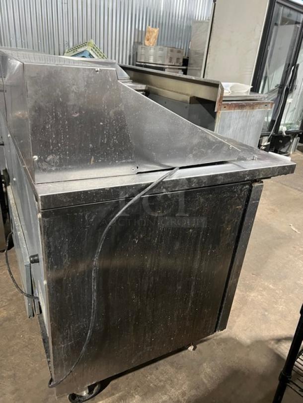 True Commercial Stainless Steel 2-Door Refrigerated Prep Table, Model TSSU-60-24M-B-ST-HC, with wired racks, on casters.