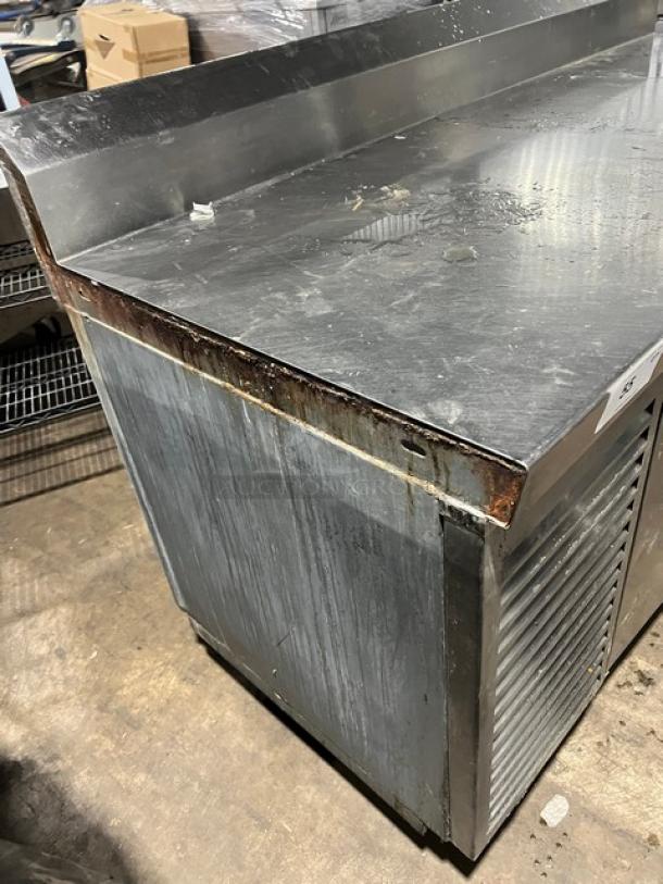 Commercial stainless steel 2-door refrigerated pizza prep table, Model 51268AM, SN: W00000028197, on legs, 115V, 1 phase, visible wear.