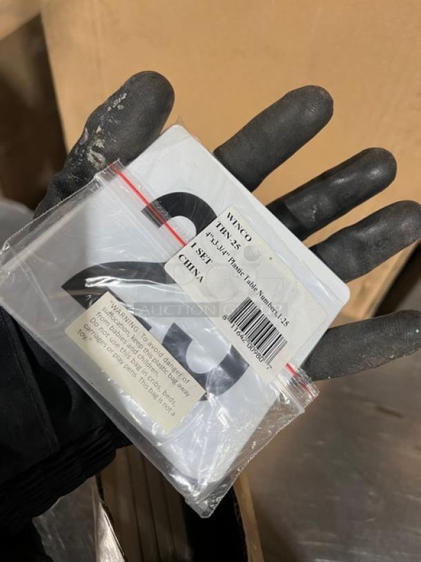 Winco placard set, model TBN25, new condition. Includes #1-25 tabletop numbers in white. Packaged in a clear plastic bag.