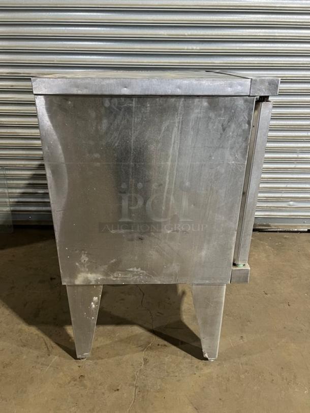 Duke stainless steel single stacked convection oven, electric powered, features wired oven rack, on sturdy legs, visible wear.