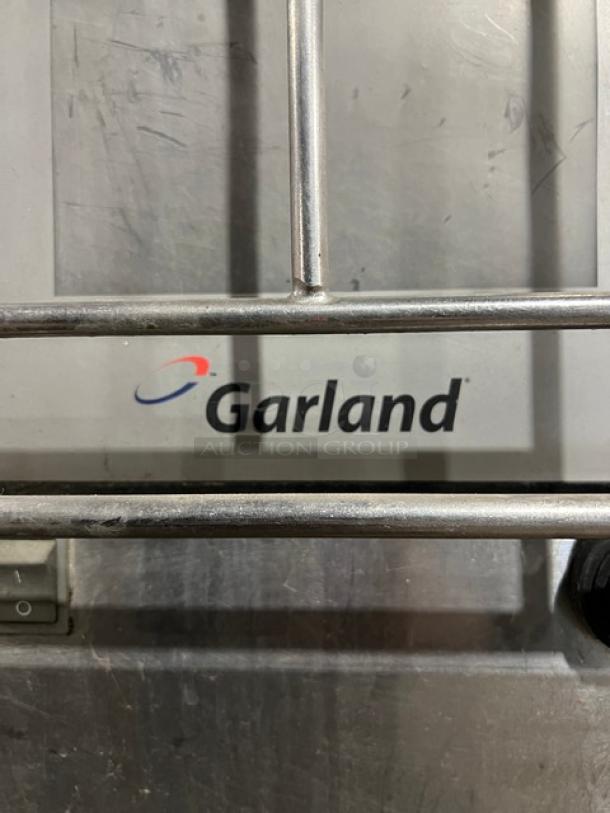 Garland CXBE12 stainless steel electric hamburger press with wavy grates, 208V, 3-phase, on casters. Garland logo visible.