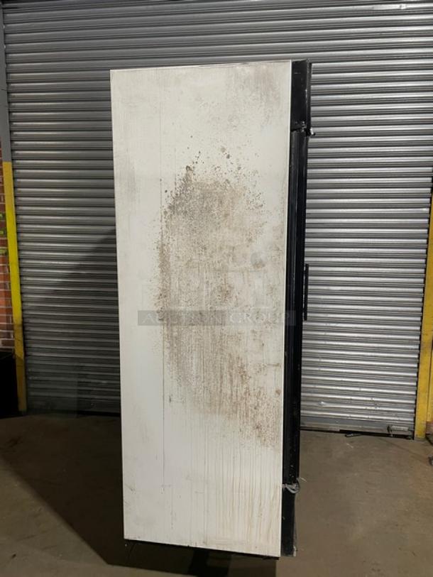 True GDM-49 commercial refrigerator, side view, noticeable wear. Double glass doors not visible. Energy Star Certified.