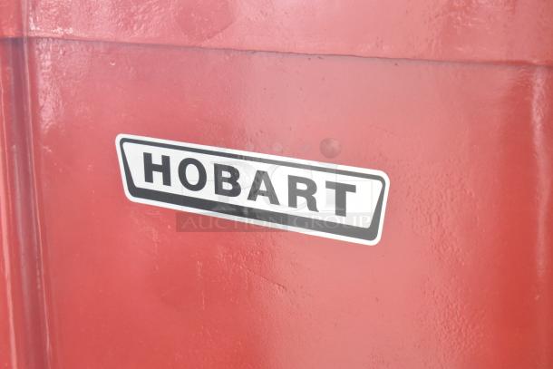 Hobart H-600T mixer with 60-quart bowl, whisk, and dough hook. Red metal, 208V, 3-phase. "Hobart" label on side.