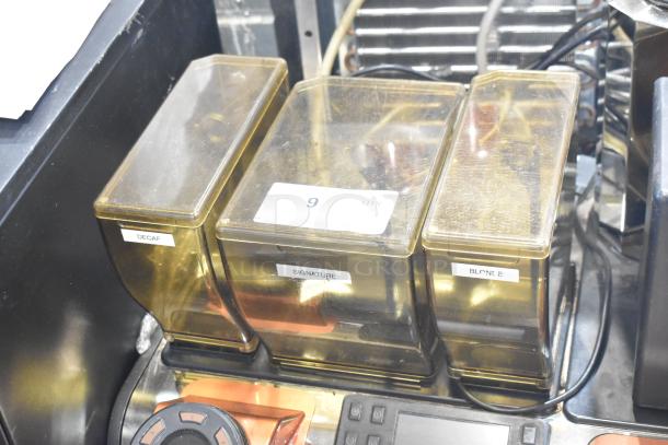 Thermoplan Mastrena II espresso machine with three labeled compartments: Decaf, Signature, Blonde; visible control panel.