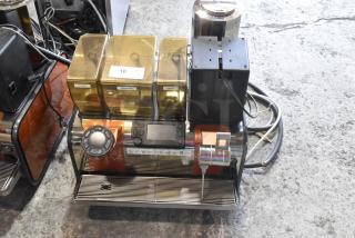 Thermoplan Mastrena II stainless steel commercial espresso machine with steam wand, labeled containers, and control panel.