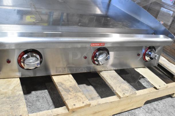 Brand new Star Max stainless steel gas-powered countertop griddle with three control knobs, caution hot label, on pallet.
