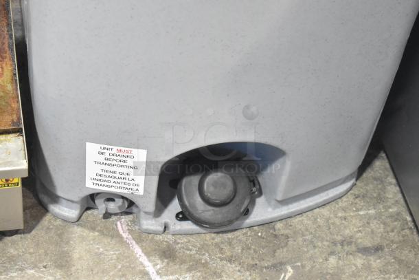 Polyjohn gray poly portable hand washing station, shown with drainage cap. Label states unit must be drained before transport.