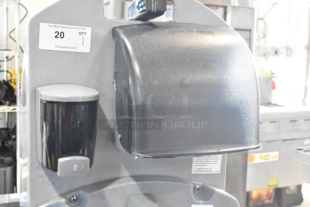 Polyjohn gray portable hand washing station, featuring soap dispenser and paper towel holder. Used condition, minor wear.