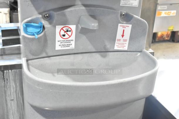 Polyjohn gray portable hand washing station, hands-free, foot-pump, visible warning labels, ideal for outdoor use.