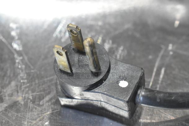 Power plug for Beverage Air UCR34Y undercounter cooler. Black cord with three-prong plug, showing slight wear.