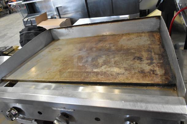 Royal stainless steel commercial gas griddle on stand; used condition, some surface wear visible. Ideal for commercial kitchens.