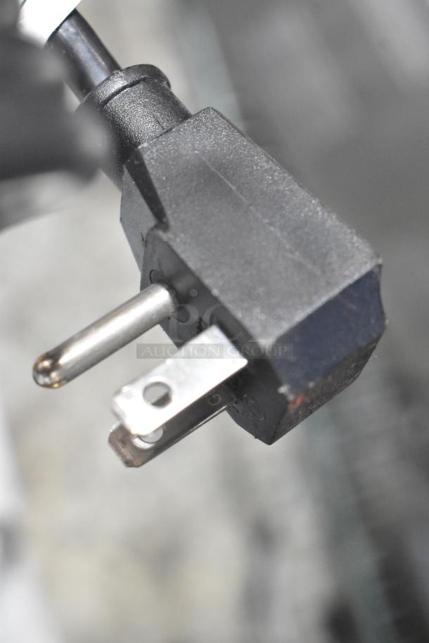 Close-up of Frigidaire FFFC07M2UW chest freezer power plug, showing standard prongs, suitable for 115 volts, 1 phase.