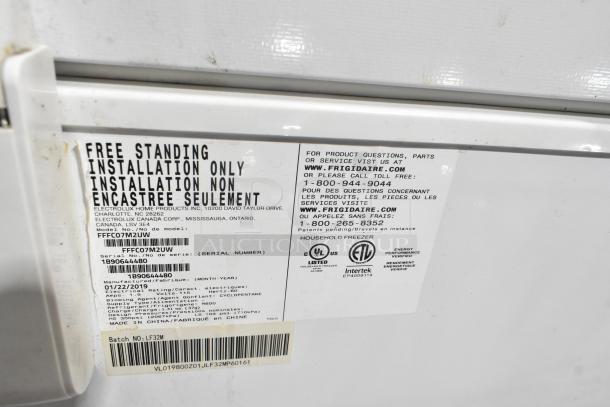 Frigidaire FFFC07M2UW metal chest freezer with hinge lid, 115 volts, tag shows model and installation details.