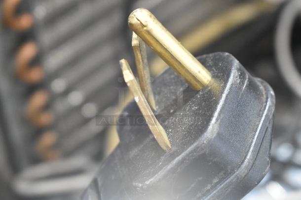 A gold-colored power plug on a Merrychef eikon e2S rapid cook oven, 208/240 Volts, 1 Phase.