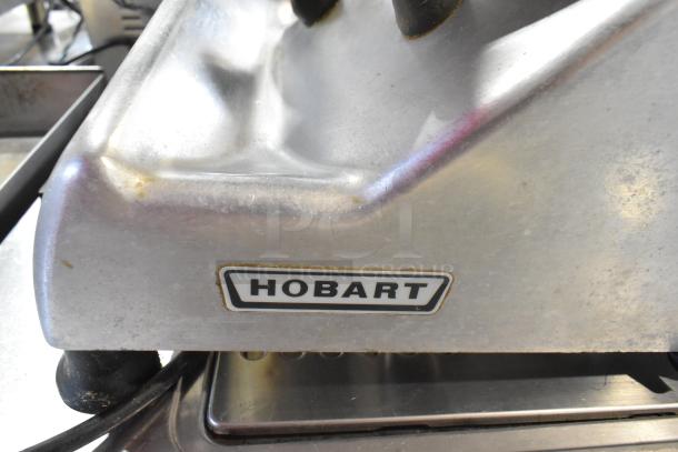 Hobart 2612 stainless steel meat slicer with blade sharpener. Features Hobart logo, 115 volts, 1 phase, commercial condition.