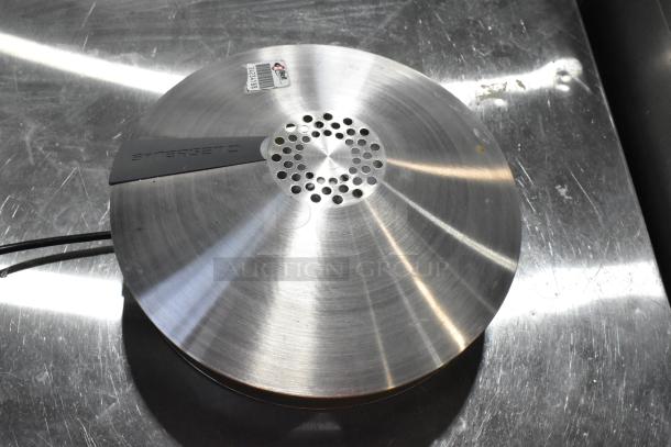 Synergetic metal bug zapper, stainless steel finish, circular design, visible brand label, slightly used condition.