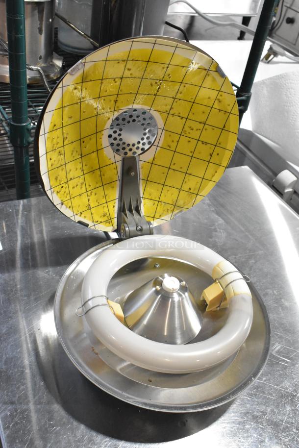 2 Synergetic metal bug zappers on shiny surface, round grid cover with insects. Appears functional, clean condition.