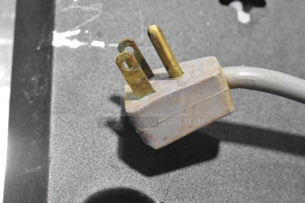 Metal bug zapper power plug, 115 volts, 1 phase, in used condition. Slight discoloration and wear visible on plug.