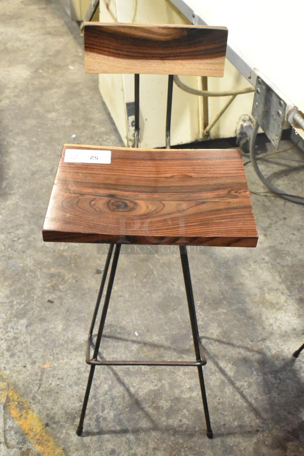 3 wooden and metal bar height chairs with polished wood seats and backrests. Black metal legs. Condition appears used.