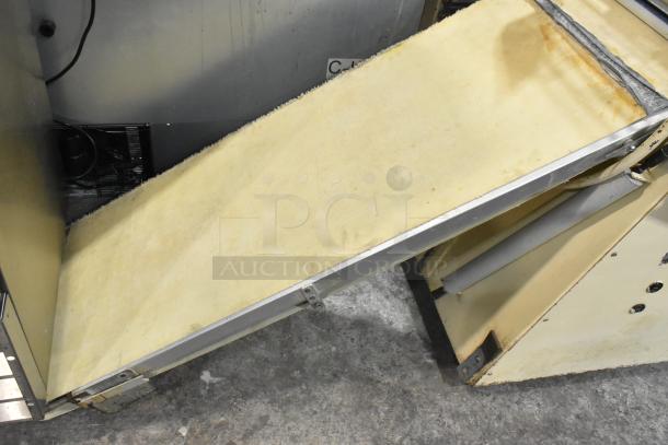 Seewer Rondo S Metal Commercial Floor Reversible Dough Sheeter, visible wear, sturdy build, reversible belt feature.