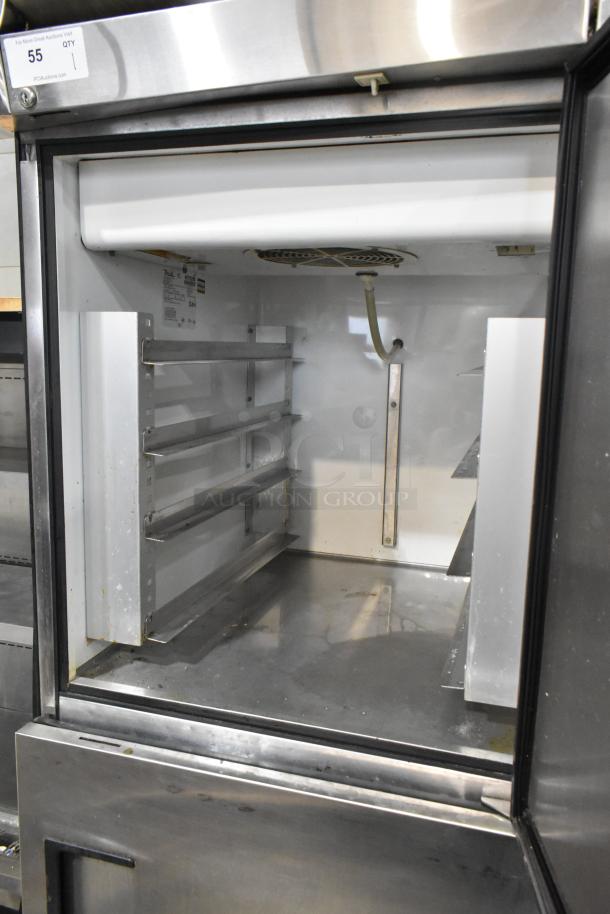 True TA1DT-2HS stainless steel 2 half door cooler freezer on casters, clean interior, some visible wear, 115V, 1 phase.