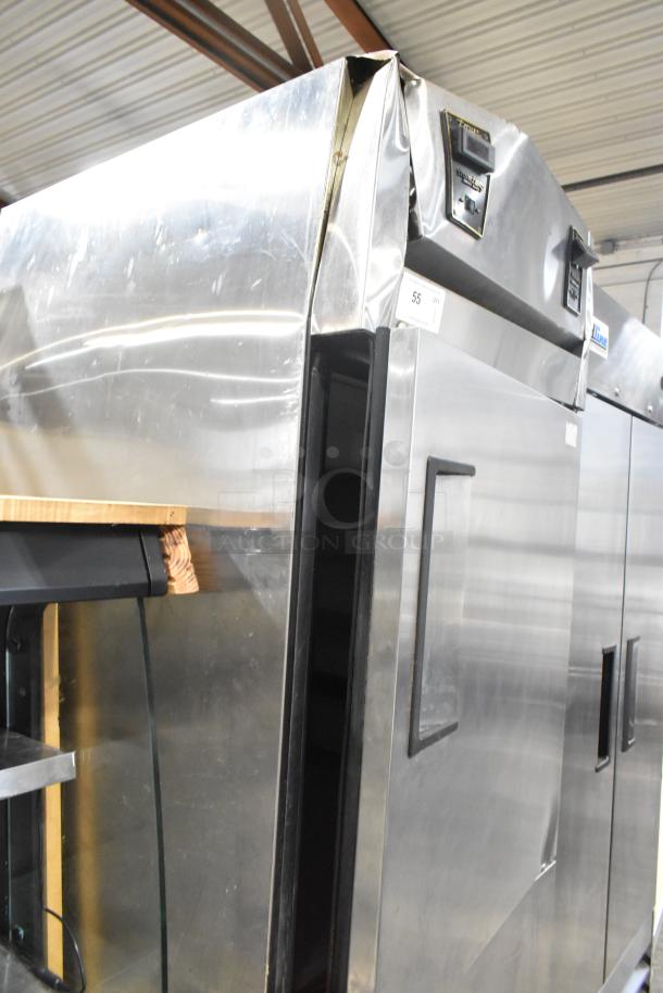 True TA1DT-2HS stainless steel reach-in cooler freezer with two half-size doors, visible dent on top panel, on casters.