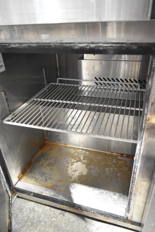 2021 Atosa MHG8406GR stainless steel 2-door undercounter freezer, interior view, visible shelving, some wear indicated.