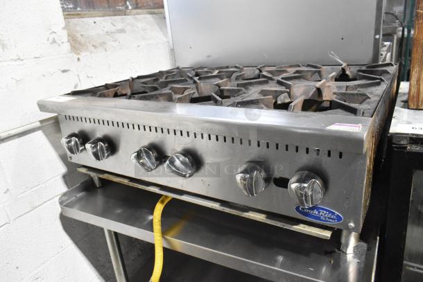 Cook Rite stainless steel 6-burner gas range on commercial stand. Features sturdy knobs, burner grates, and Cook Rite branding.