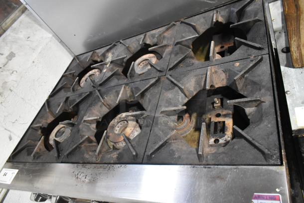 Cook Rite stainless steel commercial 6-burner gas range on equipment stand, showing signs of use.