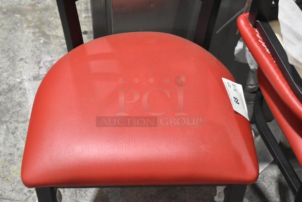 Black metal dining chair with red seat cushion, auction label "E3" visible. Good condition.