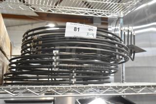 Stack of metal burners with black coils on a shelf, labeled "81, QTY X-4", brand new condition, 4 units included.