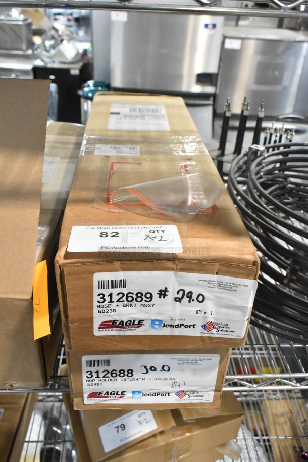 Two brand new boxes on a metal shelf: Eagle 312689 Hose with Bracket and Eagle 312688 Mop Holder. Labels show model numbers.