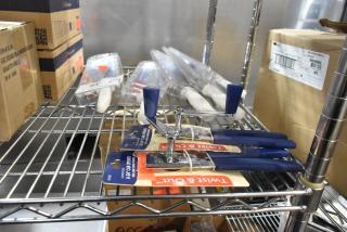7 brand new items including can openers and Dexter knives on a metal shelf, unopened in original packaging.