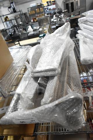 Bubble-wrapped new items including 60.74.908 colander and fryer connector strip, on a metal shelf. Tags indicate quantity and auction details.