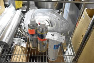 Four brand new items including Urnex Rinza tablets, Sprayon food safe grease, and a hose, displayed on a metal shelf.
