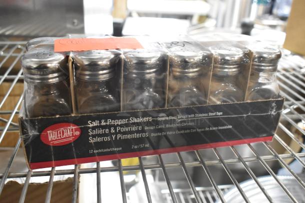 TableCraft salt and pepper shakers in packaging, new condition, set of 12 with stainless steel tops, displayed on a shelf.