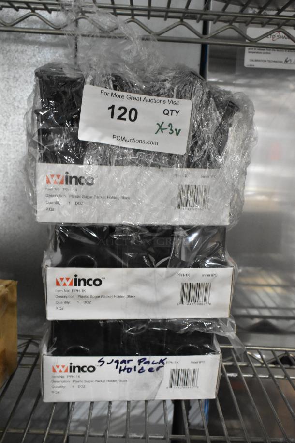 Three new Winco PPH-1K black plastic sugar packet holder caddies, wrapped in plastic, with original packaging visible.