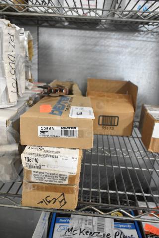 Boxes of Dexter 3" oyster knives, Cambro TG6110 tongs, Update steak forks, and Winco SP73DS drainer shelves on a shelf. Items are new.