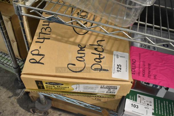 Box containing brand new Krowne spray faucet nozzle, model 17-208WL, labeled as heavy duty, on a metal shelf.