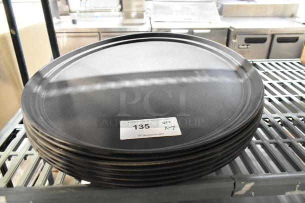 7 brand new Update GT-2700BK black oval serving trays, stackable, durable, with visible auction tag "135" indicating quantity 7.